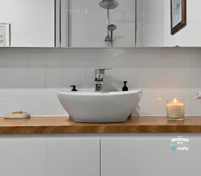 Modern bathroom featuring a sleek vessel sink on a wooden countertop, complemented by tasteful decor.