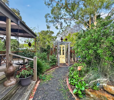 Discover a unique garden pathway leading to a beautifully landscaped outdoor space perfect for relaxation.