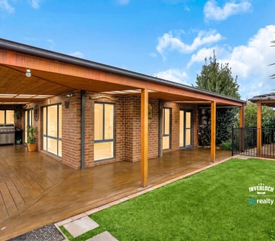 Modern outdoor living area featuring wooden decking, perfect for entertaining in a scenic, landscaped environment.
