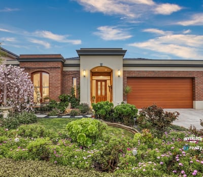 This inviting home features vibrant landscaping, a spacious garage, and a welcoming entryway.