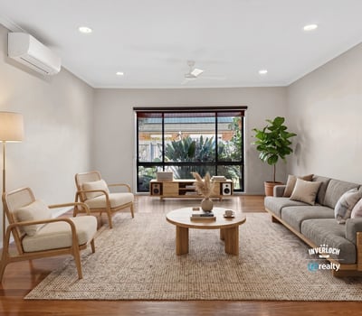 Bright living area features large windows, natural light, and modern furnishings, ideal for relaxed gatherings.