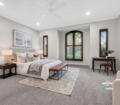 Spacious bedroom featuring large windows, plush carpet, and ample natural light for a cozy atmosphere.