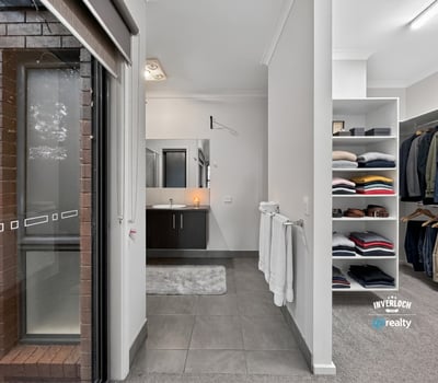 Modern bathroom with a spacious walk-in closet, featuring ample storage for an organized lifestyle.