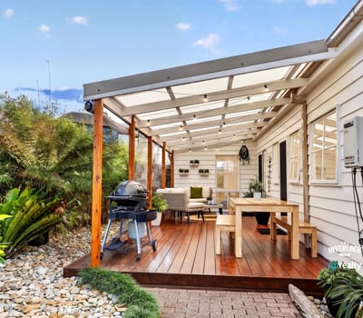 Spacious covered patio with ample seating and outdoor grilling area, perfect for entertaining and relaxing.