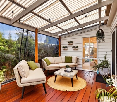 Inviting sunroom featuring comfortable seating, lush greenery, and abundant natural light for relaxed gatherings.