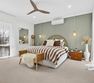Bright and spacious bedroom featuring neutral tones, a comfortable bed, and inviting decor for relaxation.
