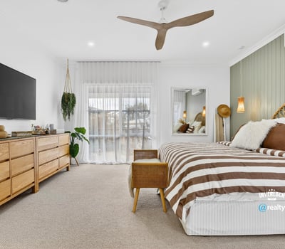 Bright and spacious bedroom featuring natural wood accents, large windows, and modern amenities for comfort.