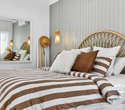 Cozy bedroom featuring a unique headboard, striped bedding, and modern accents for a relaxed atmosphere.