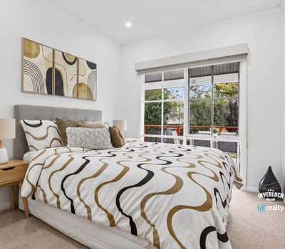 Bright bedroom featuring large windows, modern decor, and a cozy layout, ideal for relaxation and rest.