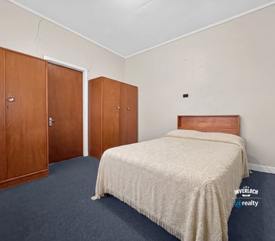 Spacious bedroom featuring a queen-size bed and built-in wardrobes, perfect for personalizing your space.