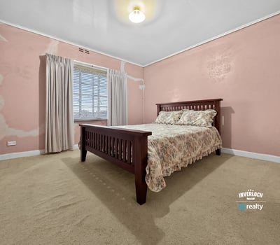 Spacious bedroom featuring natural light, ample storage, and unique wall textures ready for personalization.
