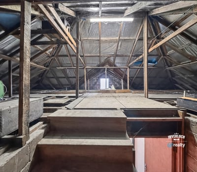 Spacious attic with exposed beams, offering limitless potential for customization or creative use.