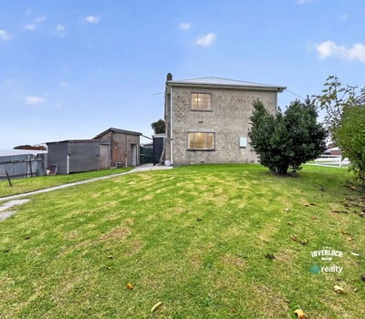 Spacious lot features a two-story home and versatile outbuilding, perfect for renovation or investment opportunities.