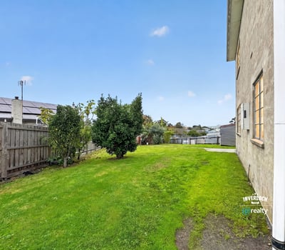 Spacious, grassy side yard offers potential for landscaping or outdoor activities, enhancing the property's appeal.