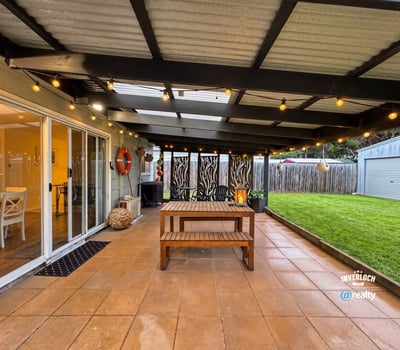 This inviting outdoor space features a spacious patio, perfect for gatherings and relaxation amidst landscaped surroundings.