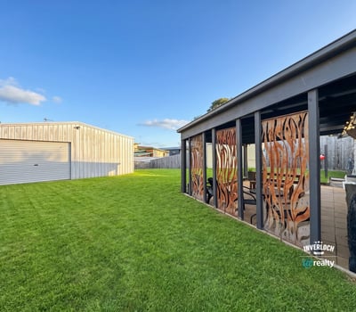 Spacious backyard featuring distinctive decor and a large garage, perfect for outdoor gatherings and hobbies.