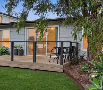 This property features a spacious deck surrounded by lush landscaping, perfect for outdoor relaxation and entertaining.