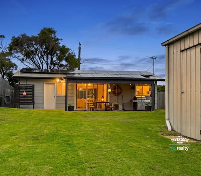 This inviting home features spacious green yard, modern amenities, and a cozy outdoor living area.