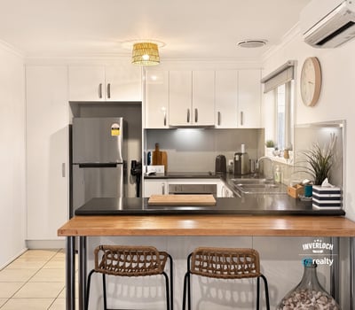 Bright kitchen featuring modern appliances, sleek cabinetry, and a cozy breakfast bar for casual dining.
