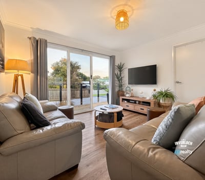 Bright living area features modern furnishings and large sliding doors that open to a scenic outdoor space.