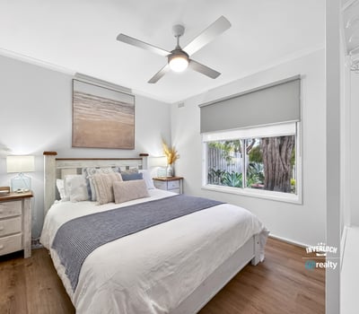 Bright, airy bedroom featuring natural light, modern decor, and a view of lush greenery outside.