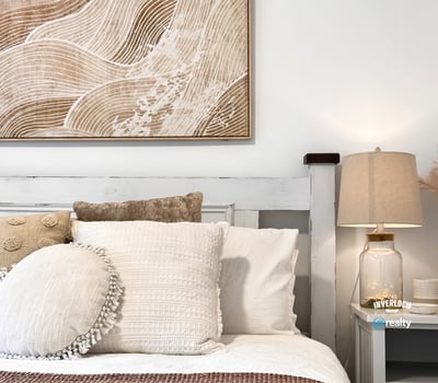 Bright and inviting bedroom featuring textured decor and warm, neutral tones for a cozy atmosphere.