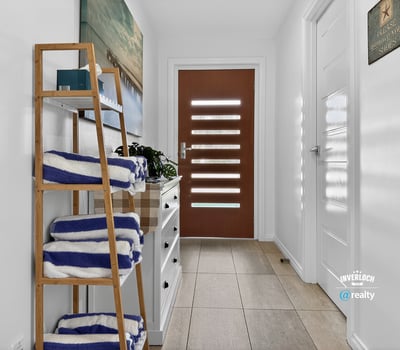 Bright and welcoming entryway featuring modern decor and practical storage solutions for your convenience.
