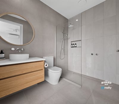 Modern bathroom featuring a spacious walk-in shower, sleek cabinetry, and contemporary finishes throughout.