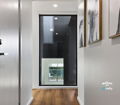 Contemporary hallway featuring sleek design and large windows, creating a bright and welcoming entryway.