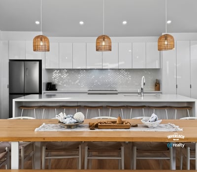 Modern open-plan kitchen featuring sleek cabinetry, a spacious dining area, and unique pendant lighting.