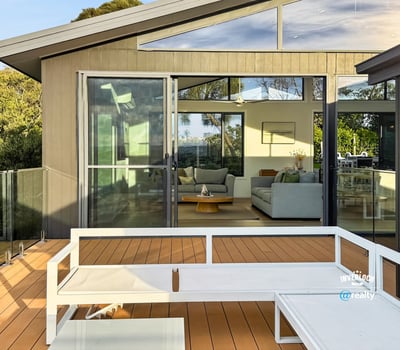 Modern home featuring a spacious deck with expansive views, seamlessly connecting indoor and outdoor living areas.