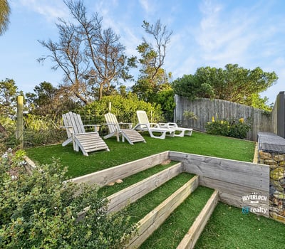 Discover a peaceful outdoor retreat featuring landscaped steps and ample seating for relaxation and enjoyment.