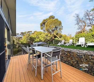 Modern outdoor patio seamlessly blends with nature, featuring ample seating and vibrant landscaping. Perfect for gatherings!