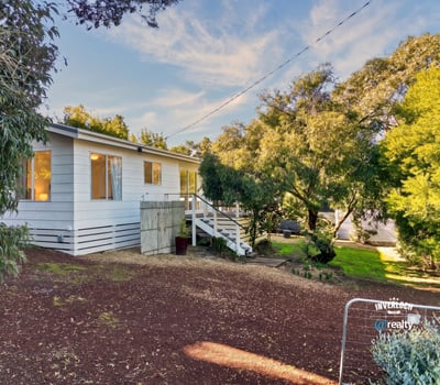 Well-maintained home nestled among lush greenery, featuring ample outdoor space and natural light throughout.