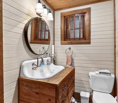 Cozy bathroom featuring a double sink vanity, natural wood accents, and soft lighting for a warm ambiance.