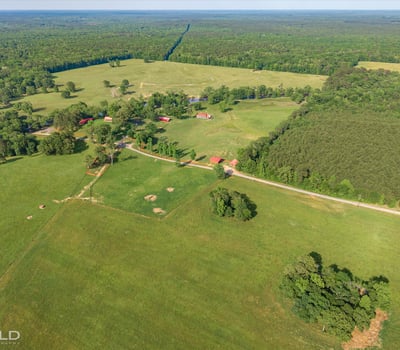 Expansive rural landscape featuring open fields, mixed woodlands, and potential for agricultural or recreational use.
