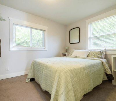 Cozy bedroom featuring natural light, comfortable bedding, and functional storage, perfect for relaxation and rest.