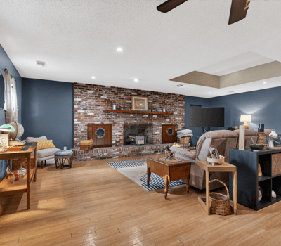 Spacious living area featuring a brick fireplace, modern amenities, and ample natural light for relaxation.