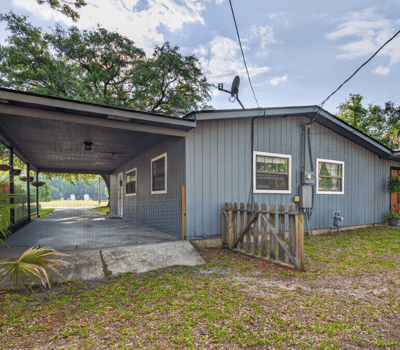 This versatile property features a spacious covered carport and a welcoming outdoor space for gatherings.