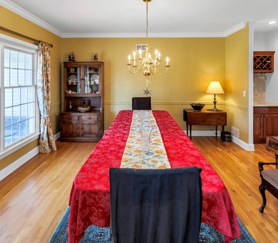 Dining Room has gleaming hardwood flooring. Afternoon sun streams through double windows.
