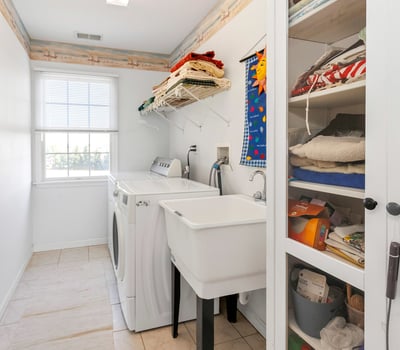 A convenient 2nd Floor Laundry Room with washtub sink and room for a storage cabinet and shelving.
