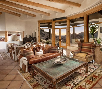 Enjoy unobstructed views of Camelback Mountain and the Valley from this airy, southwest-style great room. Soaring ceilings with wooden beams and a cozy seating area make it a welcoming space for both quiet evenings and entertaining.