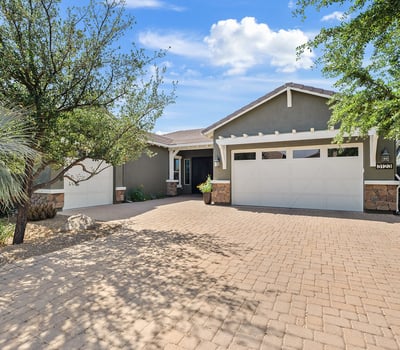 This beautifully designed Phoenix residence showcases stone accents, Craftsman-style architecture, desert landscaping, and a welcoming paver driveway that highlights pride of ownership and timeless design.