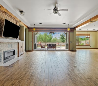 The open floor plan connects living spaces with warmth and elegance, featuring wood floors, beamed ceilings, and seamless transitions ideal for modern Phoenix living.
