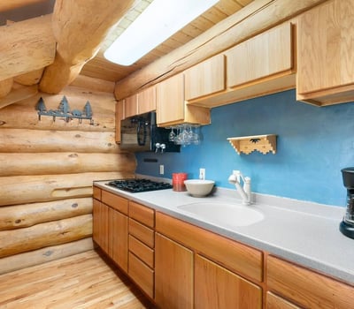 Functional kitchen design with ample storage, durable surfaces, and classic log home finishes tailored for everyday use.