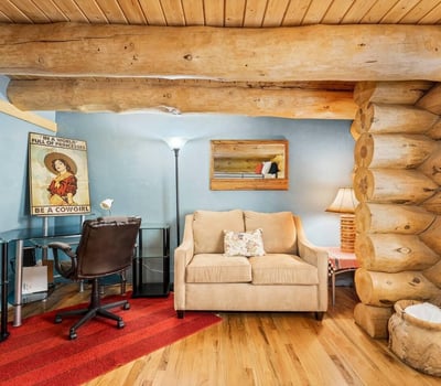 Comfortable bedroom featuring a built-in desk area and seating, offering flexibility for guests, hobbies, or a home office within a rustic setting.