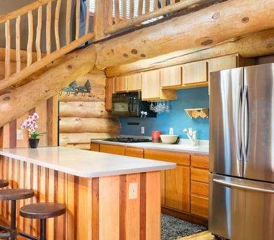 Detailed view of the kitchen island, modern appliances, and custom wood cabinetry that combine rustic charm with everyday functionality.