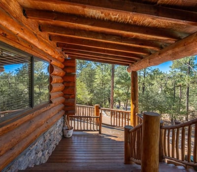 Shaded deck with log construction and wooded views, providing a quiet retreat surrounded by nature.