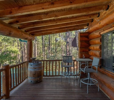 Covered deck featuring seating and forest views. Perfect for morning coffee or evening relaxation, this outdoor space enhances indoor-outdoor living in the Prescott mountains.