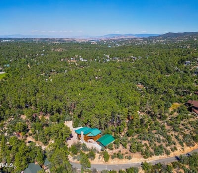 Panoramic aerial image capturing miles of forest and valley beyond the home. This view highlights the elevated position and scenic beauty that define this exceptional Prescott property.